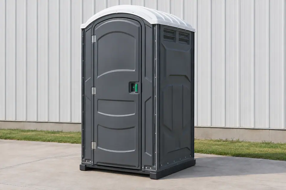 Charcoal portable toilet on a level concrete apron