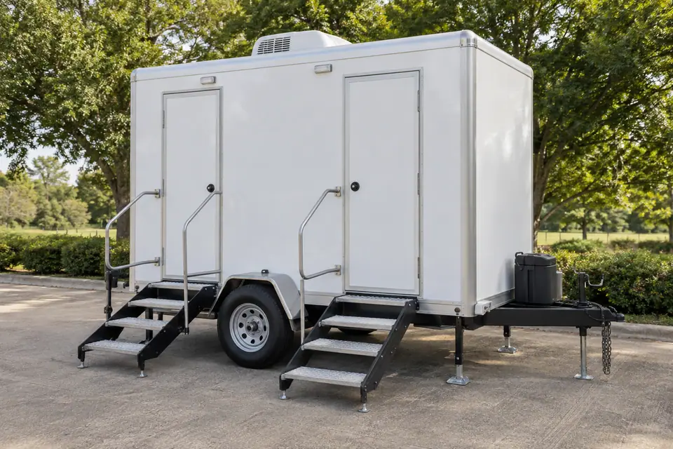 White restroom trailer with external steps and handrails